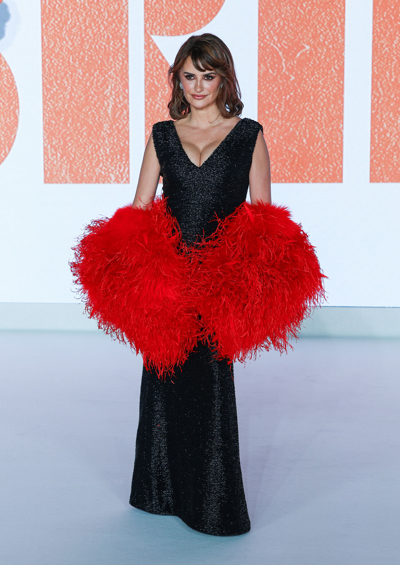 Impacta con un vestido negro con trama de hilos plateados y estola en...