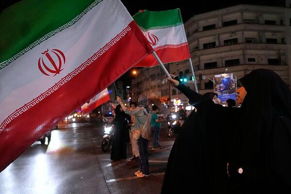 Mujeres con banderas iraníes en una reivindicación a favor del gobierno en Teherán.