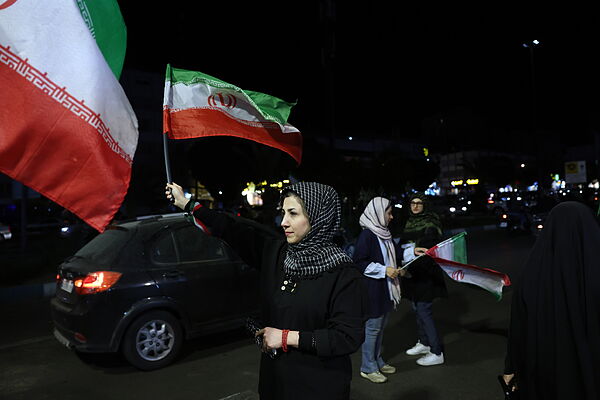 Una mujer sostiene la bandera de Irán durante una concentración en apoyo al Gobierno en Teherán.