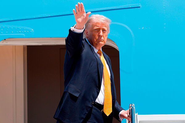 El presidente de EEUU, Donald  Trump, saluda con la mano desde las escaleras del Air Force One.