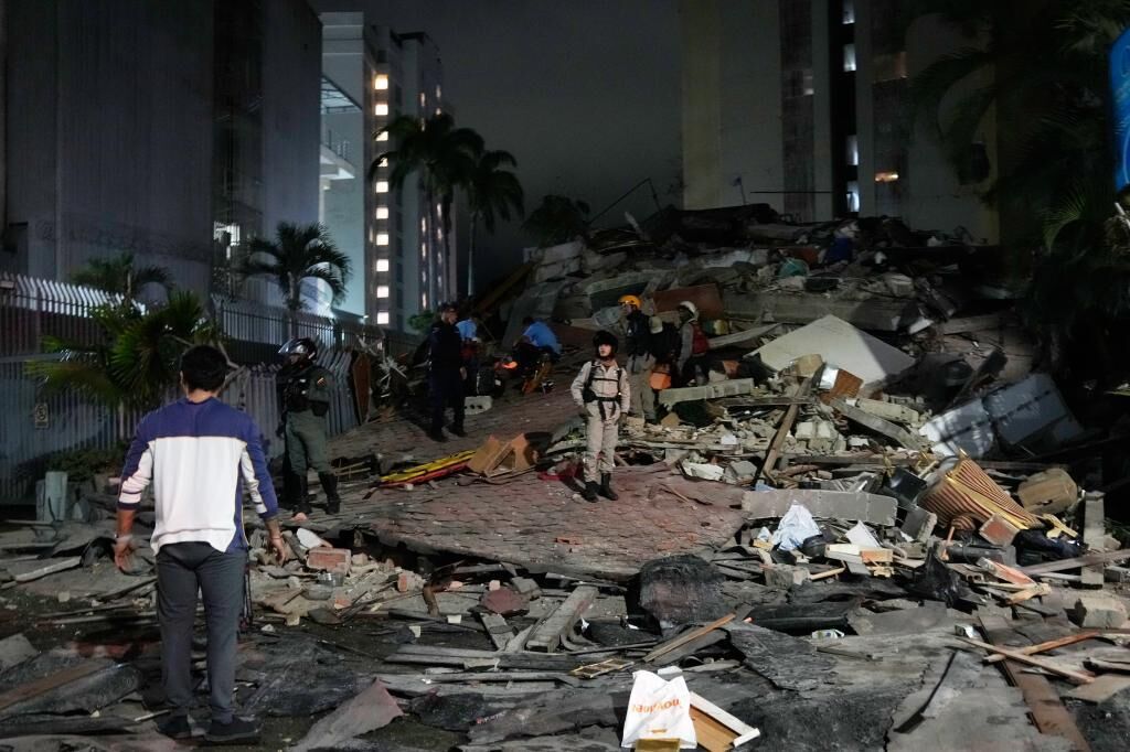 Gente caminando sobre los escombros en Caracas tras el terremoto.