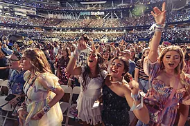 Un grupo de fans de Taylor Swift baila en primera fila de un concierto