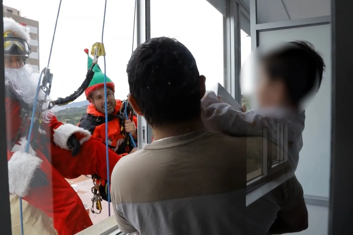 Papá Noel se descuelga de la fachada de un hospital de Barcelona para dar regalos a los niños